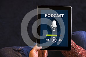 Hands holding tablet with podcast concept on screen