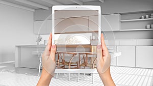 Hands holding tablet showing modern white kitchen, total blank project background, augmented reality concept, application to