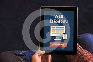 Hands holding tablet with web design concept on screen