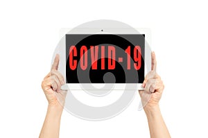 Hands holding a tablet on a white background with covid-19 text photo