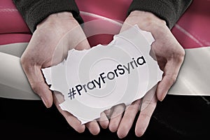 Hands holding text of pray for Syria