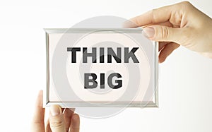 Hands are holding Think big text on a white