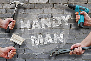 Hands holding tools on grey brickwall background with text handyman on it