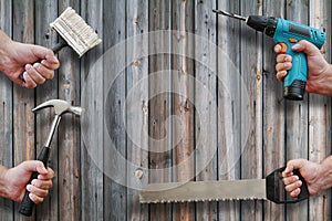 Hands holding tools on wooden background with copy space