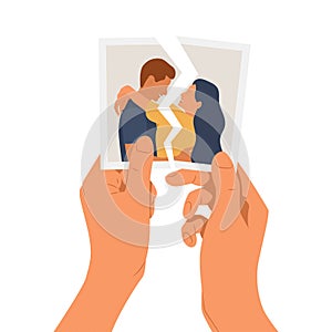 Hands holding a torn photo of a couple in love