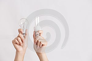 Hands holding traditional and energy efficient light bulbs