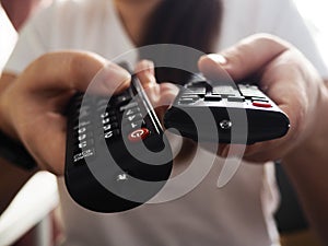 Hands holding the TV remote control, close-up at home