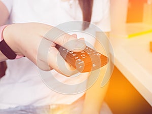 Hands holding the TV remote control, close-up at home