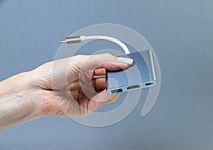 Hands holding various converter cables adapters for computers and smartphones