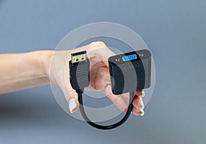 Hands holding various converter cables adapters for computers and smartphones