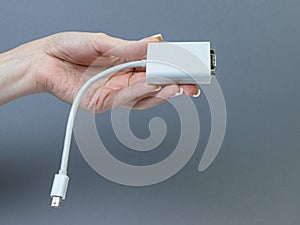 Hands holding various converter cables adapters for computers and smartphones