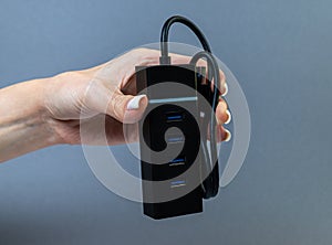 Hands holding various converter cables adapters for computers and smartphones