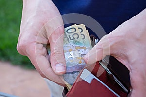 Hands holding wallet with australian dollars