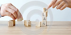 Hands holding wood blocks with plan word, business concept