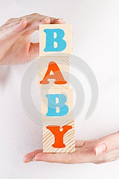 Hands holding wooden blocks BABY
