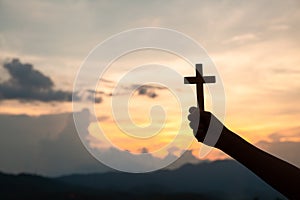 Hands holding wooden cross  on sky background, Crucifix, Symbol of Faith