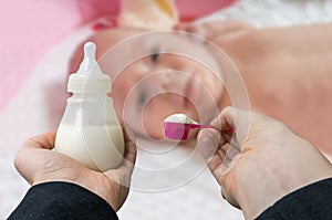 Hands holds bottle with milk formula prepaired for feeding baby