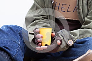 Hands of homeless with a paper cup