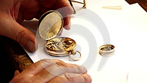 Hands of horologist repairing a pocket watch