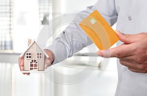 Hands with house and credit card, buy house