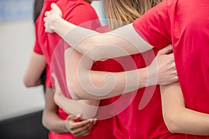 Hands hugging back of volunteer in red tshirt