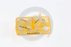 Hands of human with pill reminder box, taking medication isolated on white background, pill organizer box for monday