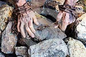 Hands of a humble slave who is not trying to free himself against a dark background