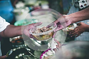 Hands of hungry beggar requesting free food from volunteers : concept of giving and sharing