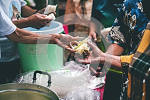 Hands of hungry beggar requesting free food from volunteers : concept of giving and sharing