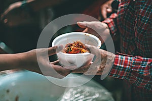 Hands of hungry beggar requesting free food from volunteers : concept of giving and sharing