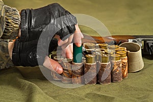 Hands of huntsman fill a bandolier of hunting ammo