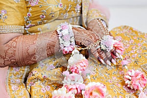 The hands of an Indian bride are decorated with Indian-style henna flowers and designs