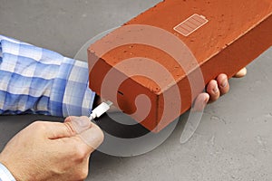 Hands insert plug usb into brick, concept of smartphone transforms into useless brick