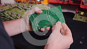 Hands inserting electronic component into printed circuit board - close up