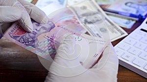 Hands inspection ukrainian money hryvnia for counterfeit money