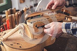 Hands of an instrument maker working on a Hurdy Gurdy