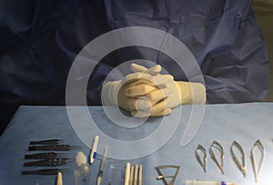 hands of an instrumentalist nurse prepared on a blue sterile field and surgical material for an ophthalmologic retinal surgery