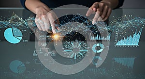 Hands interacting with futuristic digital interface displaying financial data and charts