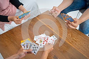 Hands issuing cards to table while playing cards together