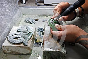 Hands of a Jade ornamental green rock carver at work photo