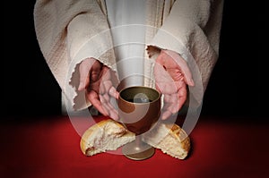 Las manos de Jesús, ofreciendo la Comunión de pan y vino.