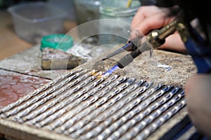 Hands of jeweller at work silver soldering