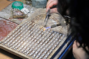 Hands of jeweller at work silver soldering