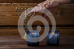 Hands of a Jewish woman over burning Shabbat candles blessing the light.