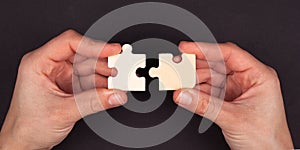 Hands join puzzle mosaic on a black background. symbol of association and communication. business strategy concept close-up