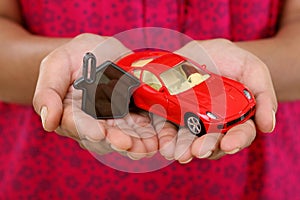 Hands with keys and red toycar