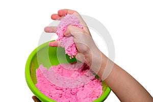 Hands of a kid playing with pink magic sand