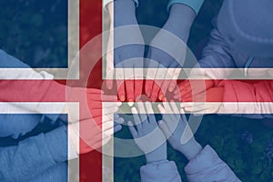 Hands of kids on background of Iceland flag. Icelander patriotism and unity concept