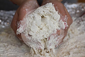 Hands knead bread