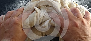 Hands knead the dough. The woman kneaded dough for baking or dumplings. Preparation of flour, water and egg mass for